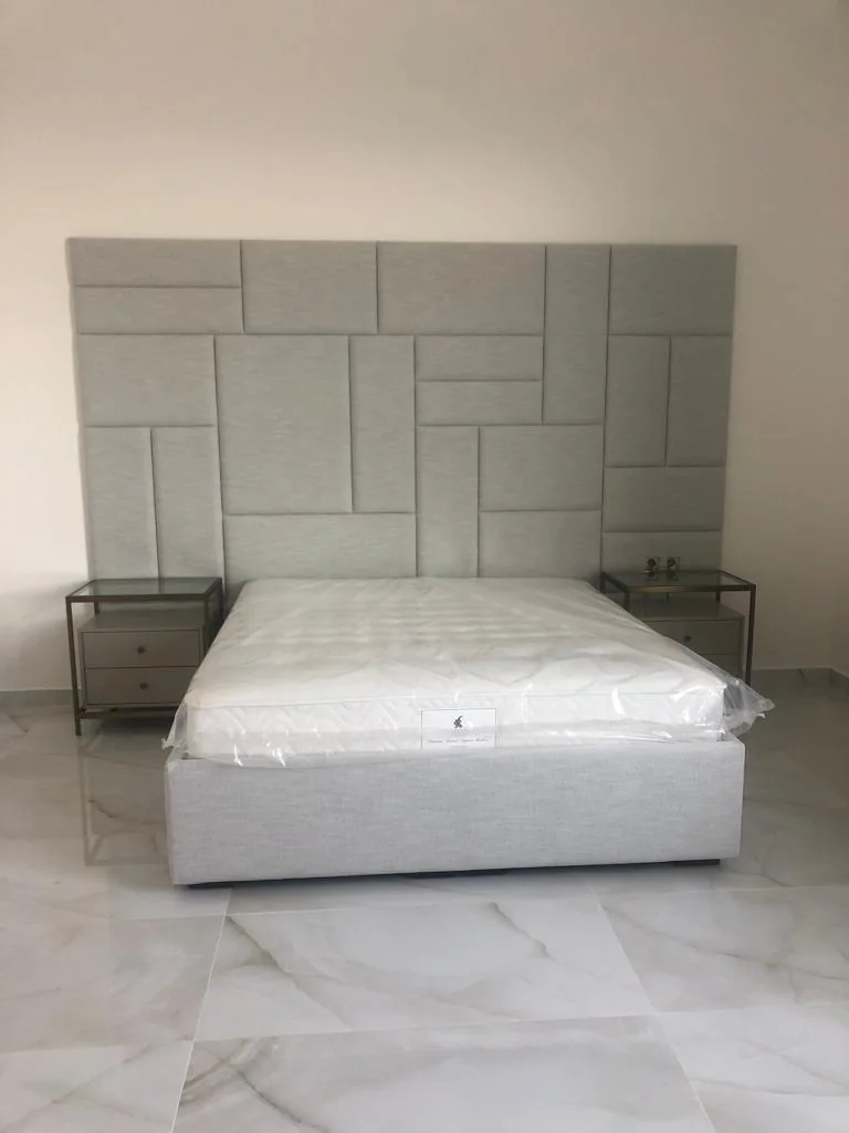سرير بلوح خلفي هندسي وطاولات جانبية